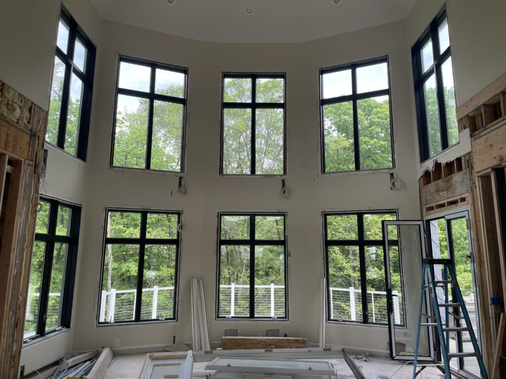 Residential window tinting installation in progress on large multi-pane windows in Monmouth County home